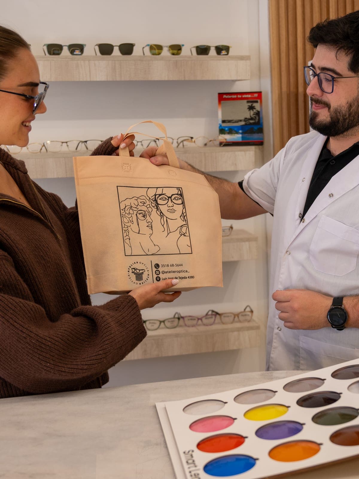 Entrega de un pedido sobre el mostrador, con la paleta de colores de cristales a la vista